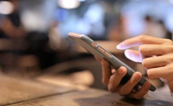 blurred background with a women holding a smartphone