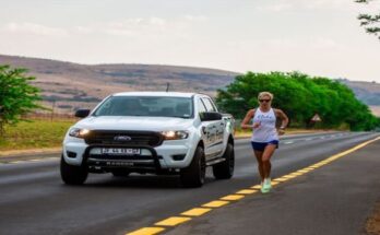 female athlete running besides a motor vehicle
