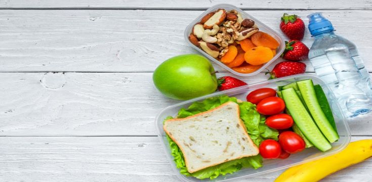 school-lunch-boxes-with-sandwich-and-fresh-vegetables-bottle-of-water-nuts-and-fruits