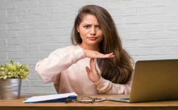 young-woman-at-desk-showing-timeout-or-stop-hand-gesture