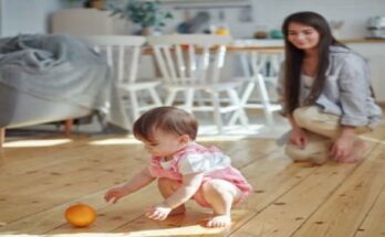 mother-watching-baby-daughter-playing-orange