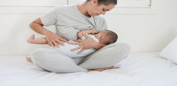 young-loving-mom-breastfeeding-her-6-months-old-baby-inside-bedroom-mother-child-love-