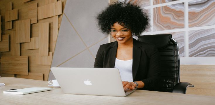 business-woman-sitting-at-desk-using-laptop