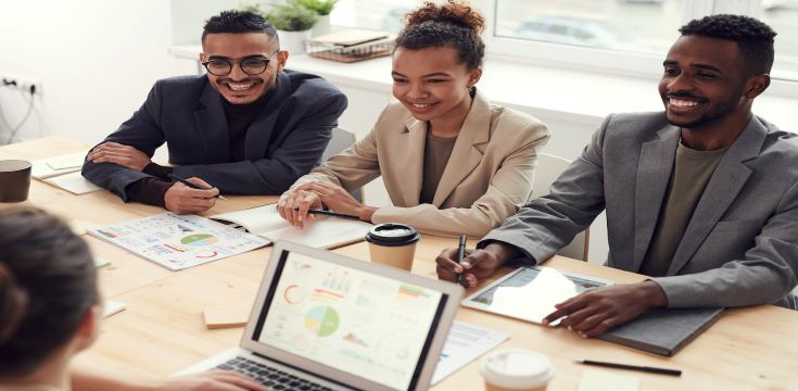 three-people-smiling-while-having-a-meeting