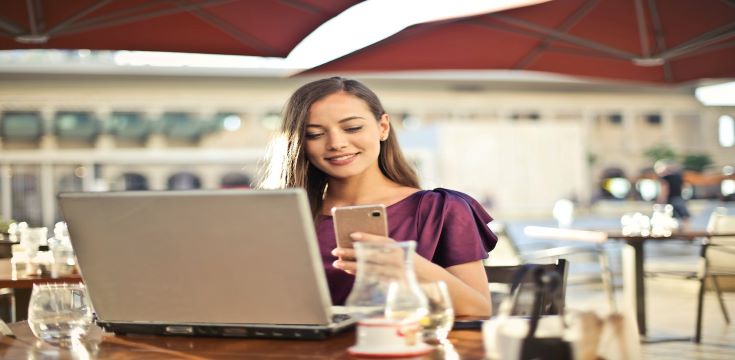 woman-wearing-purple-tshirt-while-holding-smart-phone