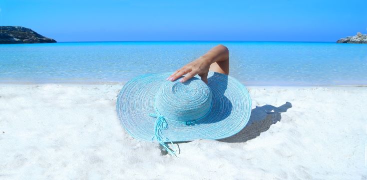 woman-on-beach-wearing-blue-sun-hat