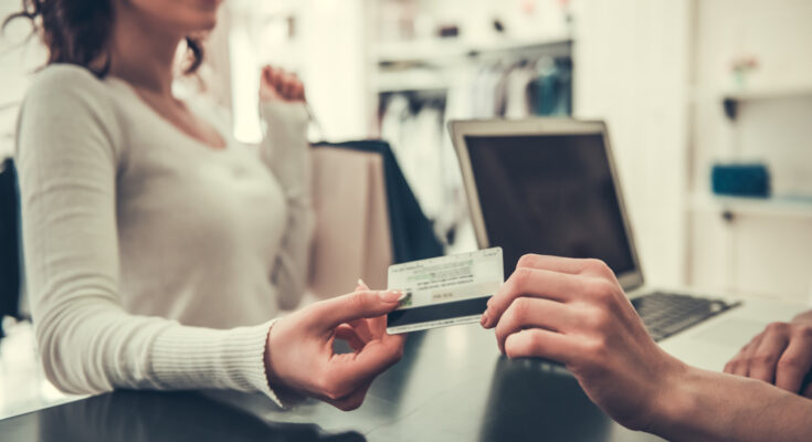 Attractive,Girl,Is,Giving,A,Credit,Card,To,Shop,Assistant