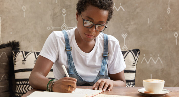 ambitious-teenager-with-dark-skin-boycut-makes-necessary-notes-organizer