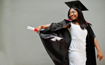 young-female-african-american-student-with-diploma-poses-outdoors