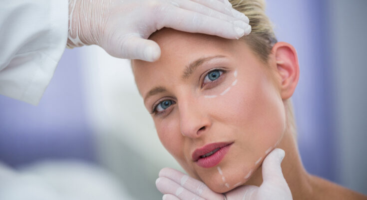 doctor-examining-female-patients-face-cosmetic-treatment