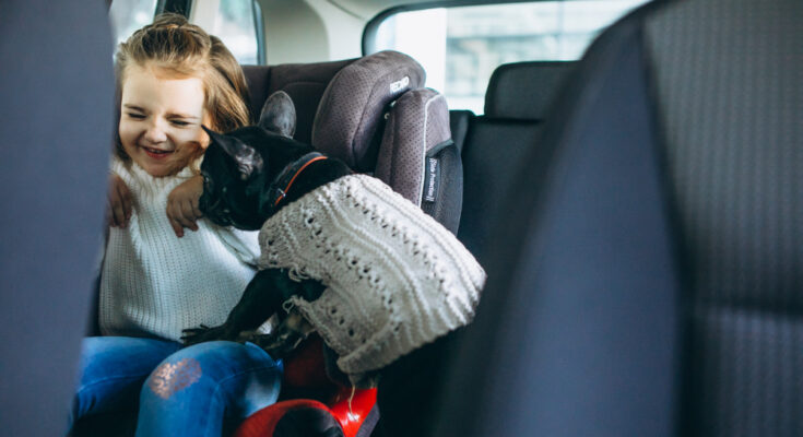 cute-little-girl-with-her-pet-sitting-back-car